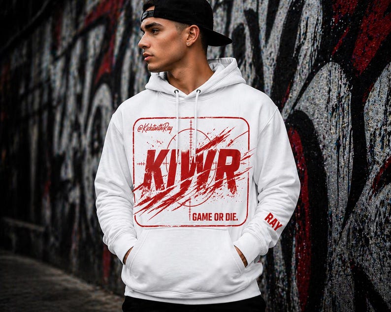 May include: White hoodie with a red graphic that says "KIWR" inside a rectangular target design. The hoodie has a drawstring hood and a front pocket. The text "GAME OR DIE" is below the graphic, and "RAY" is on the sleeve.