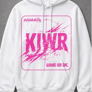 May include: White hooded sweatshirt with a pink graphic design. The design includes the text "KIWR" in large letters, the phrase "GAME OR DIE," and the text "@KickitwithRay."