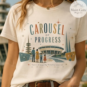 Könnte beinhalten: Ein cremefarbenes T-Shirt mit einem Grafikdruck, der den Text "CAROUSEL OF PROGRESS" und "There's A Great Big Beautiful Tomorrow" zeigt. Das Design zeigt eine Familie vor einem runden Gebäude, einem hohen Turm und Sternakzenten.