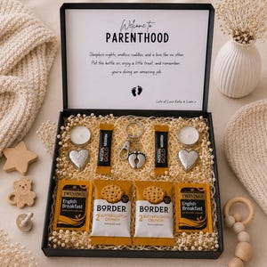 Può includere: Una scatola regalo nera contenente due stick Nescafé Gold, due bustine di tè Twinings English Breakfast, due confezioni di biscotti Border Butterscotch Crunch, due oggetti a forma di cuore, due lumini e un portachiavi con impronta di neonato.