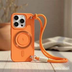 May include: Orange phone case with a matching orange lanyard. The case has a circular design with a lightning bolt symbol. The lanyard is attached with a silver clasp and white accents. The text "aura shell" is at the bottom.