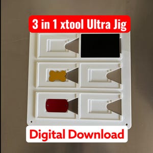 May include: A white 3 in 1 xtool Ultra Jig with multiple rectangular cutouts. The jig contains a black rectangular plate, a gold bone-shaped tag, and a red rectangular tag. The text 3 in 1 xtool Ultra Jig and Digital Download is visible.