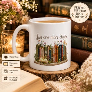 Może przedstawiać: Biały ceramiczny kubek z napisem "Just one more chapter" i kolorową ilustracją książek. Kubek stoi na drewnianej podstawce, z tłem z książek i kwiatów. Kubek nadaje się do kuchenki mikrofalowej i zmywarki.