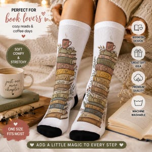 May include: White socks featuring a design of a stack of books, a coffee cup, and glasses. The socks have black heels and toes. Text on the socks says "Add a little magic to every step". The socks are labeled "Soft, comfy & stretchy" and "One size fits most".