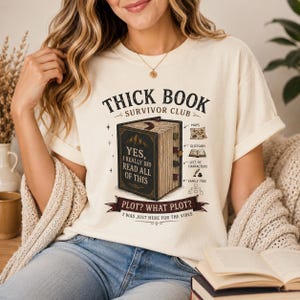 May include: Cream-colored t-shirt with the text "THICK BOOK SURVIVOR CLUB" and a graphic of a book. The book graphic has the text "YES, I REALLY DID READ ALL OF THIS" and "PLOT? WHAT PLOT? I WAS JUST HERE FOR THE VIBES".