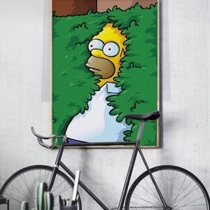 Könnte beinhalten: Gerahmter Cartoon-Druck mit Homer Simpson, der durch grüne Büsche späht. Homer ist gelb mit großen Augen und einem weißen Hemd. Im Vordergrund befindet sich ein schwarzes Fahrrad, mit Kaktus und anderen Gegenständen auf einem Tisch.