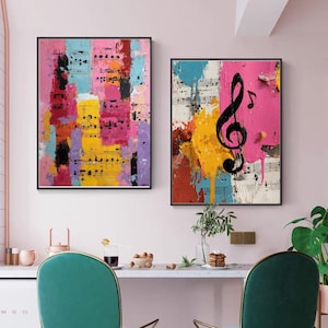 May include: Two framed abstract art pieces. One features colorful vertical blocks with musical notes. The other has a large black treble clef over a pink background with musical notes. Both have black frames.