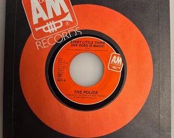 May include: A vintage 45 RPM vinyl record by The Police, titled "Every Little Thing She Does Is Magic." The record is in its original orange and black sleeve, featuring the A&M Records logo. The record label is orange with black text.