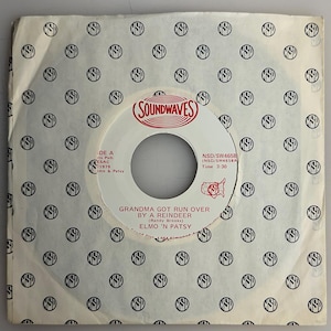 May include: A vintage 45 RPM vinyl record by Elmo 'n Patsy, titled "Grandma Got Run Over By A Reindeer." The record label is white with red text and a "Soundwaves" logo. The record is in a patterned paper sleeve.