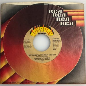 Può includere: Un disco in vinile rosso e giallo con il titolo "Be Thankful For What You Got" di William DeVaughn. Il disco è di Roxbury Records Corp. e ha il logo RCA sull'etichetta.