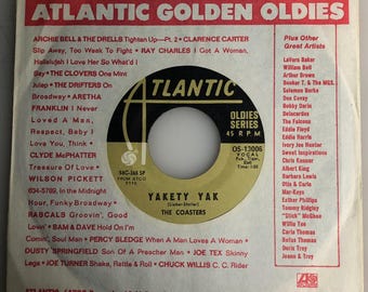 May include: A black and white vinyl record with a red and white Atlantic Records label. The record features the song "Yakety Yak" by The Coasters. The record is part of the Atlantic Golden Oldies series.