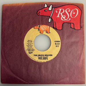 May include: A vintage vinyl record and sleeve featuring the song "Too Much Heaven" by the Bee Gees. The record label is yellow with black text, and the sleeve is a maroon color. The RSO logo is prominently displayed.