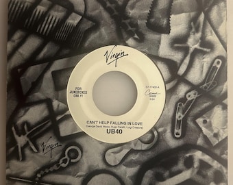 May include: A black and white 7-inch vinyl record featuring the song Can't Help Falling in Love by UB40. The center label is white with black text, including the Virgin logo, For Jukeboxes Only, and song credits. The sleeve has a collage design.