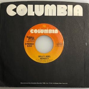 Può includere: Un disco in vinile nero e arancione con l'etichetta Columbia Records. Il disco è intitolato "Honesty" di Billy Joel. Il disco è del 1976 e ha una durata di riproduzione di 3:50.