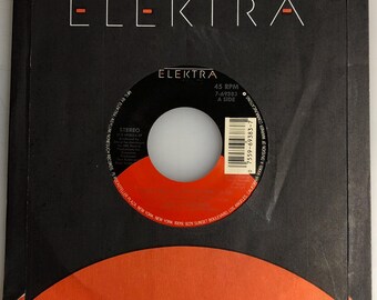 May include: A black vinyl record with a red and white label. The label has the text "Elektra" and "45 RPM" printed on it. The record is for the song "Steppin' Out" by the band "The Fixx".