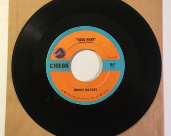 May include: A black vinyl record with a blue, orange, and white label. The label features the text "CHESS", "GOOD NEWS" (Morganfield), "MUDDY WATERS", "Arc-2:40", "1667", and "8510".