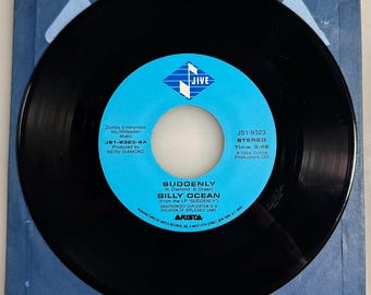 May include: A black vinyl record with a blue and white label featuring the text "SUDDENLY" by Billy Ocean. The label includes the Jive Records logo and production details. The record is in a blue paper sleeve.