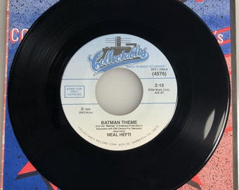 May include: Black vinyl record with a white label. The label has the title "Batman Theme" by Neal Hefti, the record label "Collectable Record Corp.", and the text "Back to Back Hit Series" with the series number "(4576)".