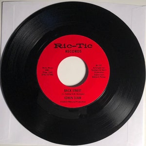May include: A black vinyl record with a red label. The label says "Ric-Tic Records" and features the song title "Back Street" by Edwin Starr. The record is a Solid Hitbound Production.