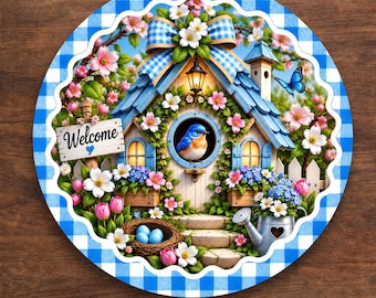 May include: A round aluminum sign featuring a blue and white gingham border. The center depicts a blue birdhouse with a blue bird, surrounded by pink and white flowers, a blue butterfly, a nest with blue eggs, and a metal watering can.