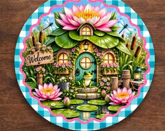 May include: A round aluminum sign featuring a whimsical frog house topped with a large pink lotus flower, surrounded by lily pads, cattails, and dragonflies. A wooden signpost reads Welcome. The border has a blue and white checkered pattern.