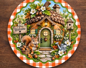 May include: A round aluminum wreath sign featuring a scalloped edge with an orange and white gingham border. The center depicts an acorn-shaped house with a green door, a squirrel holding an acorn, a wooden welcome sign, and a metal watering can.