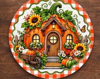 May include: A round aluminum wreath sign featuring a pumpkin-shaped house with a wooden door, windows, and a lantern. The scene includes sunflowers, daisies, a wooden cart, and a butterfly, all framed by an orange and white checkered border.