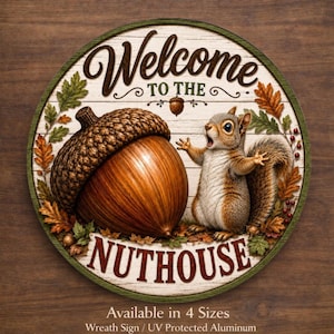 May include: A round wooden sign with the words "Welcome to the Nuthouse" in a decorative font. The sign features a large acorn and a surprised squirrel, surrounded by fall leaves. The sign is available in four sizes.