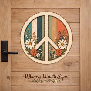 May include: A round peace sign with a colorful, vertical striped background, adorned with daisies and foliage. The sign is mounted on a wooden door. The text "Whimsy Wreath Signs" is at the bottom.
