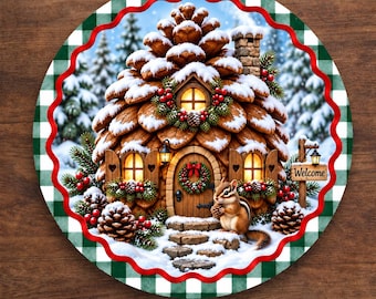 May include: A round aluminum sign featuring a winter scene of a house shaped like a pinecone covered in snow. A chipmunk stands near the front door, which has a wreath. The sign has a green and white buffalo plaid border and the text Welcome.