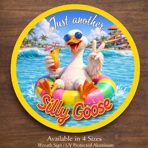 May include: A round yellow sign featuring a cartoon goose wearing sunglasses and floating in a colorful inner tube. The goose holds a tropical drink and makes a peace sign. Text reads "Just another Silly Goose."