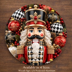 May include: A round Christmas wreath featuring a detailed nutcracker design. The nutcracker is red, black, and gold, surrounded by ornaments in red, black, white, and gold. The text "Available in 4 Sizes" is at the bottom.