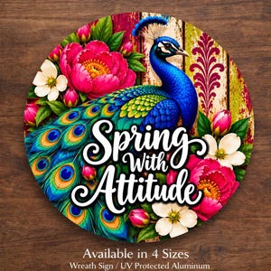 May include: A circular aluminum sign featuring a vibrant peacock with blue and green plumage, surrounded by large pink peonies and white flowers. The text "Spring With Attitude" is printed in white script across the center of the design.