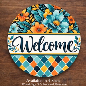 May include: A round aluminum sign featuring a floral pattern with orange and teal flowers on a black background. The center has a white horizontal band with the word Welcome in dark blue script. The bottom section has a teal, orange, and yellow quatrefoil pattern.