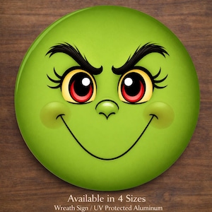 May include: A round, green sign featuring a cartoon face with black eyebrows, eyelashes, and a smiling mouth. The eyes are yellow with red irises. The sign is on a wooden background. Text at the bottom reads "Available in 4 Sizes".