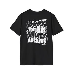Puede incluir: Camiseta negra con el texto blanco "Overthinking Solves Nothing" en una fuente audaz y estilizada. La camiseta tiene mangas cortas y cuello redondo. Una prenda casual.