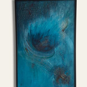 Könnte beinhalten: Abstraktes Kunstwerk in einem schwarzen Rahmen. Das Kunstwerk zeigt ein strukturiertes, geschichtetes Design mit Blau- und Türkistönen. Die Komposition umfasst wirbelnde Muster und ein kreisförmiges Element, das ein dynamisches visuelles Erlebnis schafft.