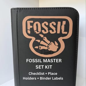 Może przedstawiać: Czarny zestaw Fossil Master Set z brązowym logo i tekstem. Logo zawiera słowo "FOSSIL" nad projektem przypominającym dłoń. Poniżej znajduje się tekst "FOSSIL MASTER SET KIT Checklist + Place Holders + Binder Labels."