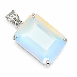 May include: A rectangular opalite pendant featuring a faceted, translucent stone with milky white and soft blue hues. The stone is secured in a silver-toned metal setting with four prongs and includes an ornate, filigree-style metal bail at the top.