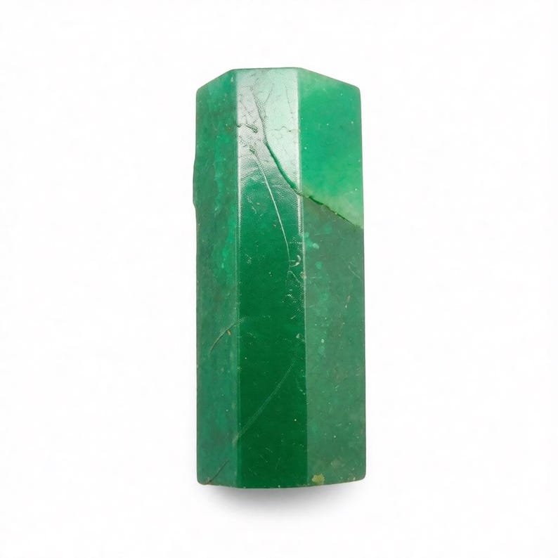 Puede incluir: Un esp&eacute;cimen de cristal de esmeralda hexagonal de color verde vibrante. La piedra presenta una superficie lisa y pulida con fracturas internas naturales visibles e inclusiones que crean una textura compleja y multifac&eacute;tica en todo el cuerpo.