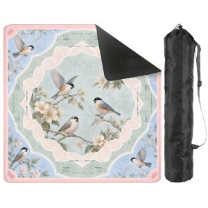 May include: A square mat featuring a light blue and pink floral pattern with illustrations of small birds perched on branches and in flight. The mat has a black underside and is accompanied by a black cylindrical carrying bag with a shoulder strap.