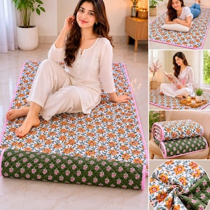 May include: A rectangular floor mat featuring a white base with a vibrant orange and yellow floral pattern on one side and a quilted olive green fabric with a small pink floral print on the reverse, finished with a bright pink fabric border.