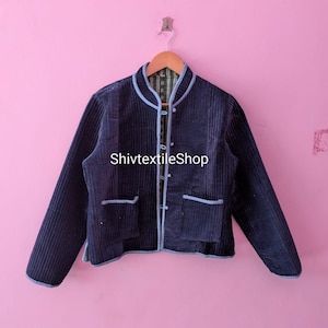 Puede incluir: Una chaqueta acolchada de color azul marino oscuro con costuras verticales, cuello mao y ribetes azul claro en los bordes. La chaqueta cuenta con dos bolsillos delanteros, cierre frontal de botones y el texto ShivtextileShop en el frente.