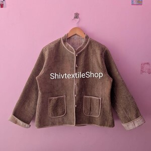 May include: A brown corduroy jacket with a mandarin collar, two front pockets, and button closures. The jacket has a contrasting trim and cuffs. The text "ShivtextileShop" is printed on the front of the jacket.