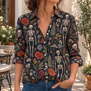 May include: A long-sleeved button-down shirt featuring a dark background with a repeating pattern of human skeletons, red poppies, yellow wildflowers, and green ferns. The shirt has a classic collar, a front button placket, and cuffed sleeves.