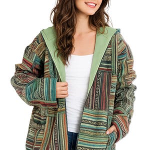 May include: A patchwork hooded jacket with a light green hood lining and pockets. The jacket features a mix of vertical and horizontal striped patterns in shades of green, red, and brown. The jacket is open, revealing a white top.