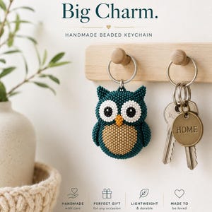 May include: A handmade beaded keychain shaped like an owl with dark teal, white, and tan beads, featuring a metal ring and a round brass tag engraved with the word HOME. The text Small Owl. Big Charm. Handmade Beaded Keychain is visible.