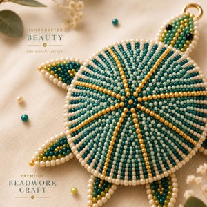 May include: A turtle-shaped ornament crafted from small beads in shades of teal, light green, and metallic gold, with a cream-colored beaded border. The turtle features black bead eyes and a gold-tone metal loop at the top for hanging purposes.
