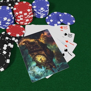 Könnte beinhalten: Pokerset auf einer grünen Filzoberfläche. Enthält Stapel roter, blauer und schwarzer Pokerchips und eine Hand Spielkarten. Eine Karte zeigt ein Uhrturm-Design. Die Karten zeigen die Zahl 10 und die Farben Herz, Karo und Pik.