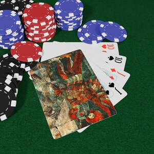 May include: Poker game setup with stacks of red, blue, and black poker chips on a green felt surface. A hand of cards is visible, including a card with an ancient art design and several cards showing the number 10.